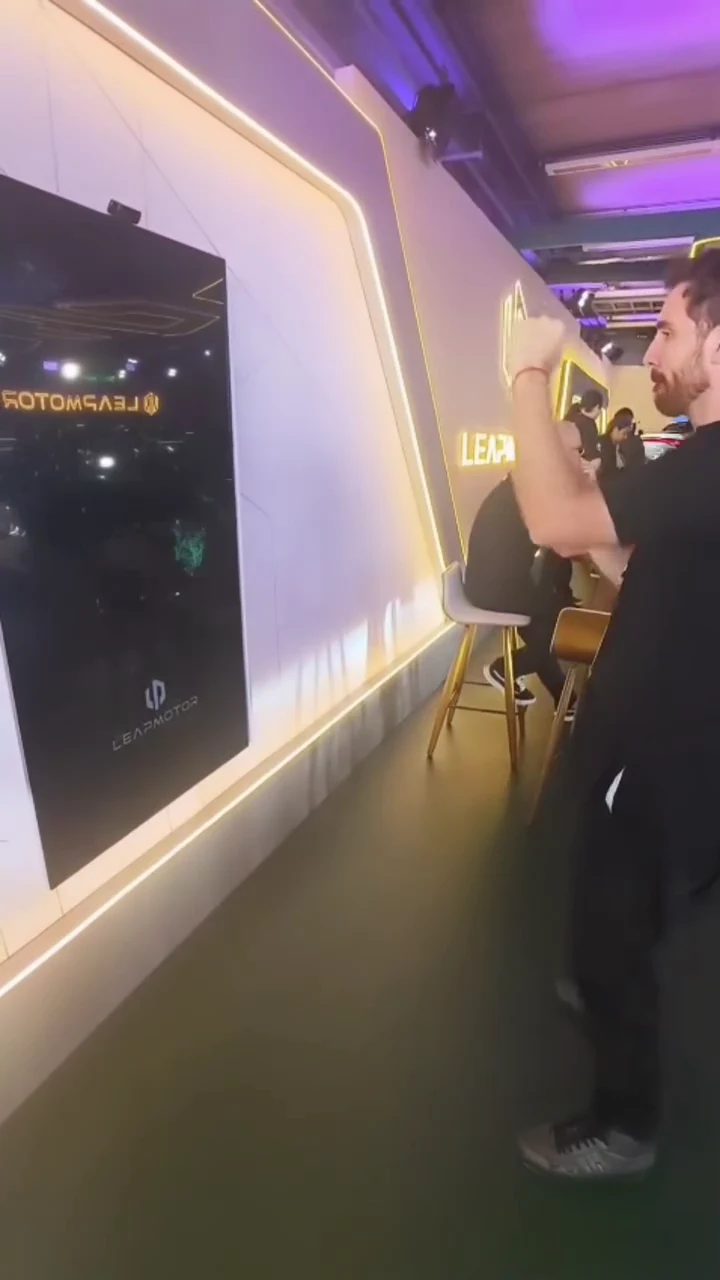 Participante movimentando os braços em frente à instalação da Leap Motor
